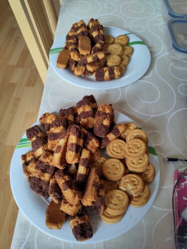 Auf zwei Tellern sind zwei unterschiedliche Kekse verteilt. Ein Teller ist deutlich voller als der andere.